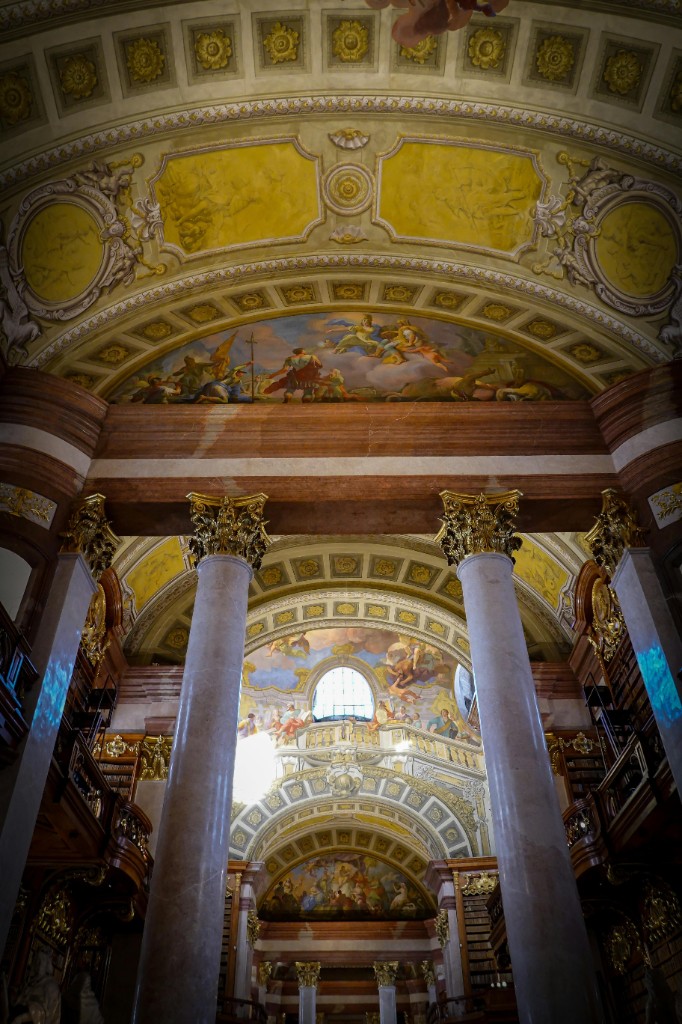 Ornate historic library interior with vaulted ceilings and frescoes