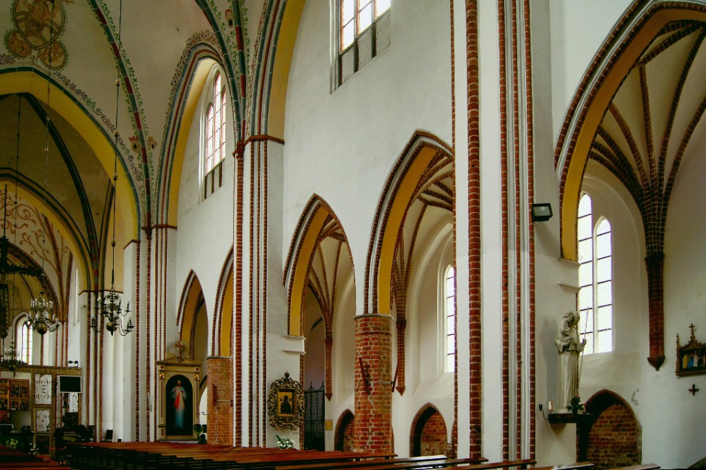 Historic church with twin spires surrounded by green trees